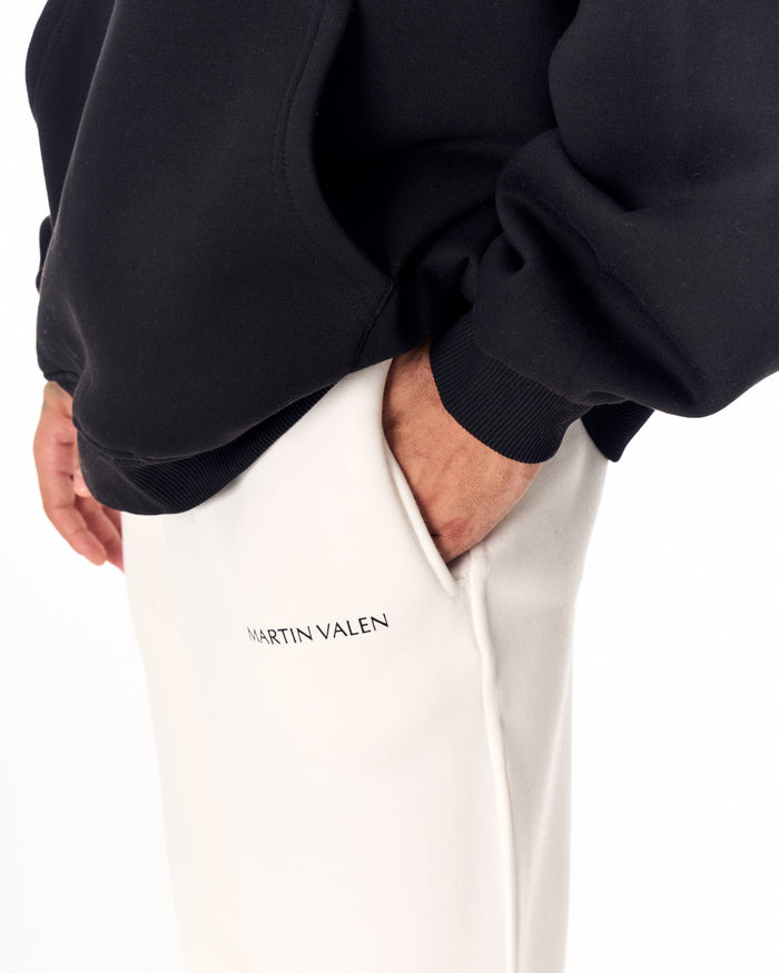 Martin Valen MV Basic White Jogger in white, side close-up of waist and pocket with hand inside and visible Martin Valen logo