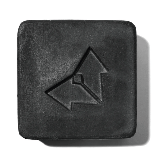 Charcoal Cleansing Bar x Brisa Hennessy | Vertra is a square black cleansing bar with a minimalist arrow logo embossed, designed for skincare and body care.