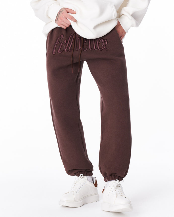 Martin Valen brown "Fell Better" joggers in motion, front leg view with white sneakers visible